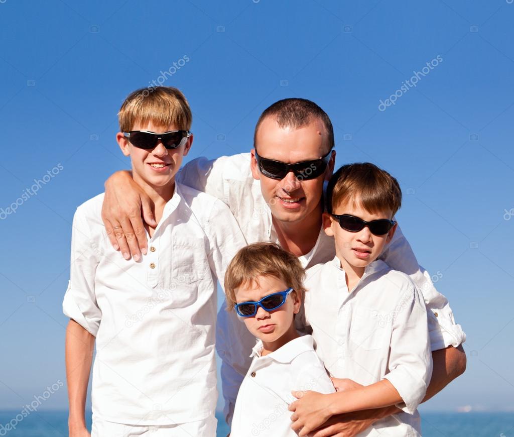 father and sons walking on beach