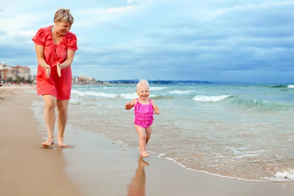 Mãe feliz e sua filhinha na praia — Fotografia de Stock