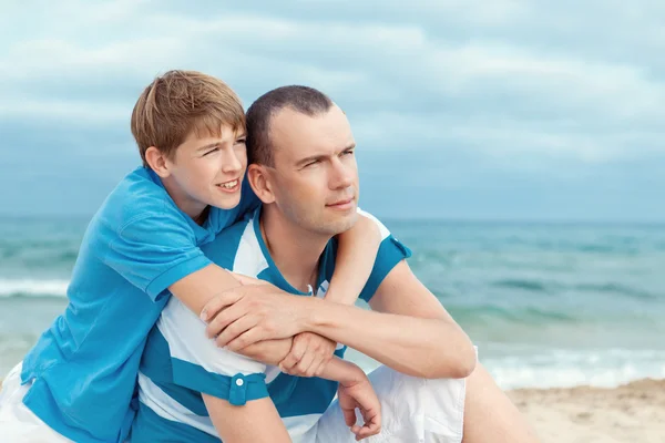 Ojciec i syn siedzi nad morzem — Zdjęcie stockowe