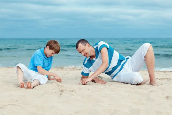 Pai e filho sentados no mar — Fotografia de Stock