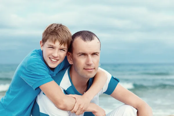 Far och son som sitter på havet — Stockfoto