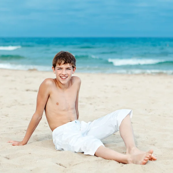 Portrét dospívající seděl na písku u moře — Stock fotografie