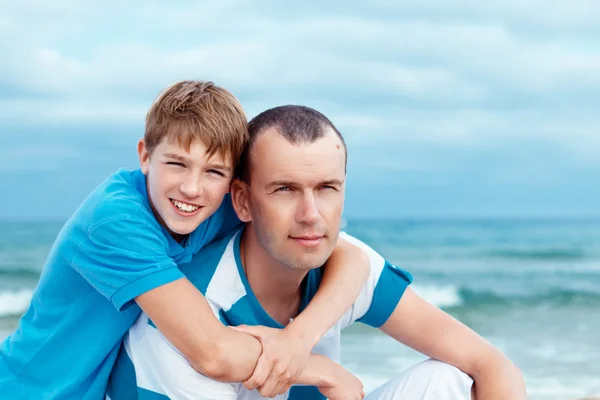 Vader en zoon zittend op zee — Stockfoto