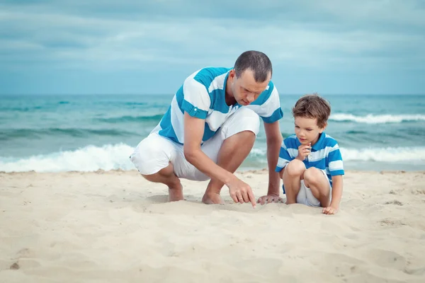 Baba ve oğlu deniz üzerinde oturan — Stok fotoğraf
