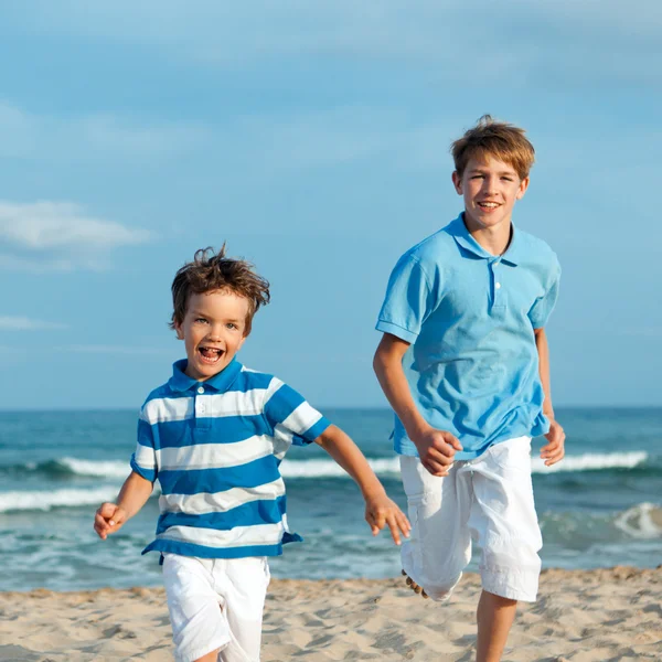 Deux frères courent sur la plage — Photo