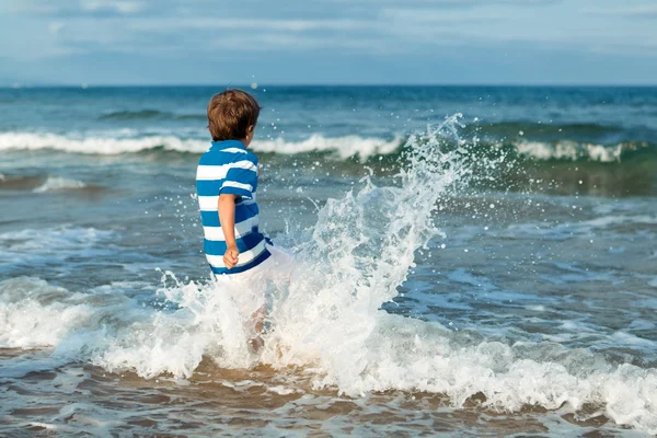 Niño feliz juega en la playa — Foto de Stock