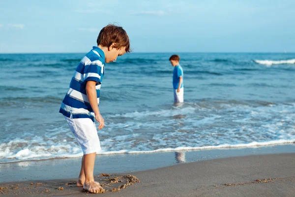 Niño feliz juega en la playa — Foto de Stock