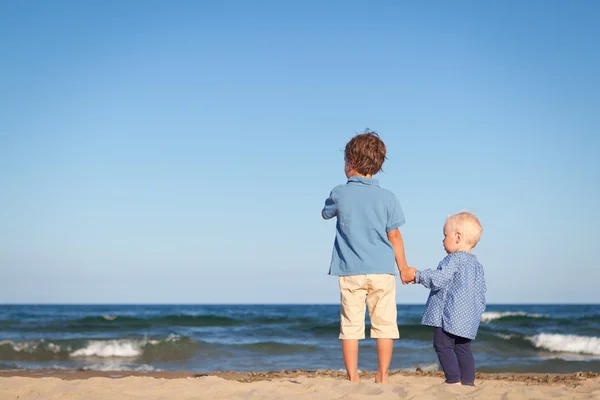 Hermano y hermana a pie cerca del mar — Foto de Stock