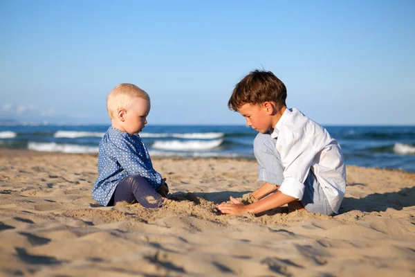 Bror og søster leker i sand på stranda – stockfoto