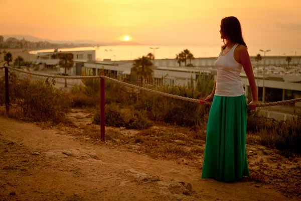 Gün batımında kumsal boyunca yürüyen güzel bir kız — Stok fotoğraf