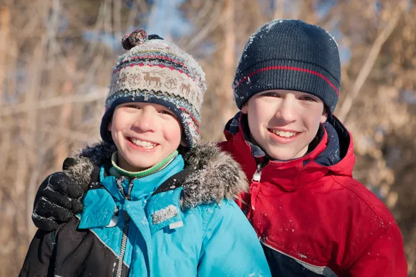 Niños en ropa de invierno riendo mientras juegan en snowdrift —  Fotos de Stock