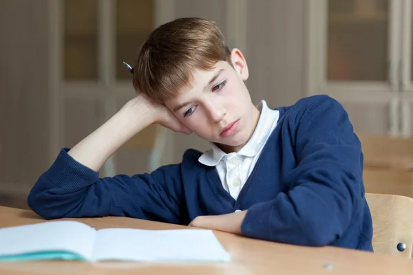 Diligent preschool sitting at desk, classroom — Stock Photo, Image