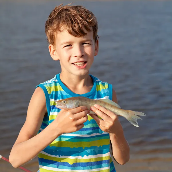 Boy holding fish and smiling — Stock Photo, Image