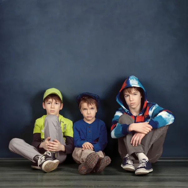 Retrato de tres hermanos sobre fondo azul —  Fotos de Stock