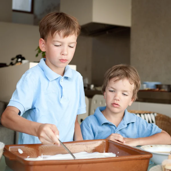 Dos chicos hacen un pastel en la cocina —  Fotos de Stock