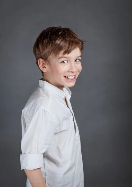 Retrato de feliz, alegria menino no fundo agray — Fotografia de Stock