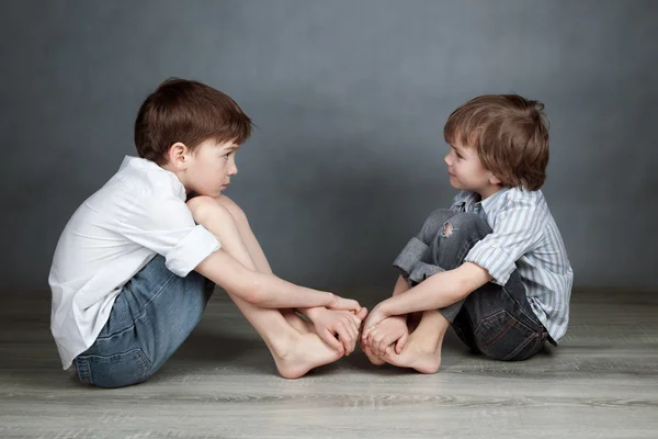 Portrait de deux frères heureux sur fond agray — Photo