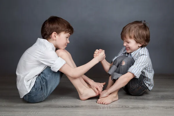 Retrato de dois irmãos felizes no fundo agray — Fotografia de Stock