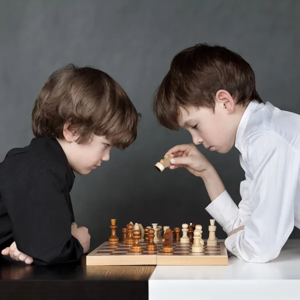 Dois meninos sérios jogando xadrez, estúdio Imagens De Bancos De Imagens
