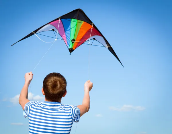 Jongen vliegt kite in blauwe hemel — Stockfoto