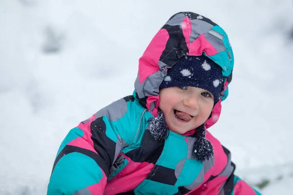 小女孩在冬天走路 小孩表现出舌头 — 图库照片