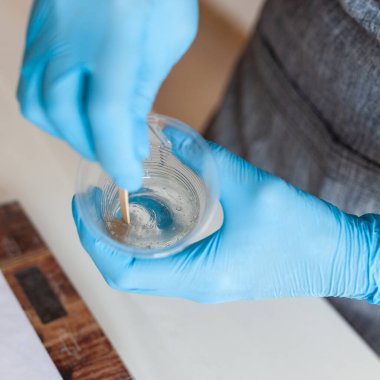 Yaratıcılık için iki reçine bileşeni karıştırma işlemi, eldivenli eller, reçine sanatı ustası sınıfı