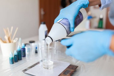 Reçine bir bardağa doldurulur, belli bir ölçekte tartılır, reçine yaratıcılığı süreci, kapalı alanlarda