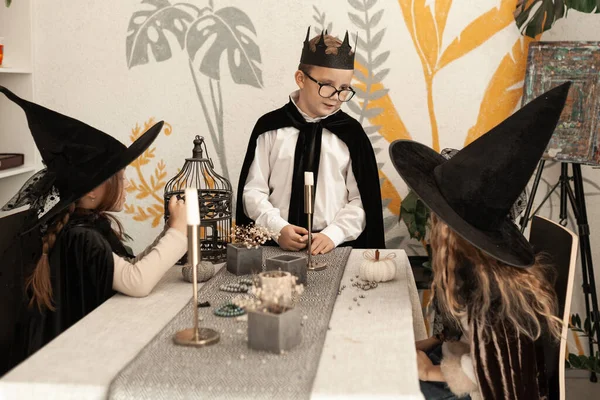 Cadılar Bayramı Için Kostüm Giymiş Neşeli Çocuklar Masada Oturup Sohbet — Stok fotoğraf