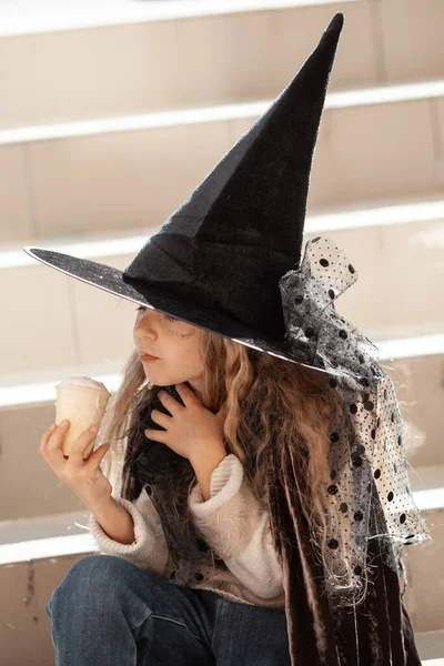 女孩坐在外面的楼梯上 孩子们穿着派对服装 头上戴着女巫帽 吃着冰激凌 — 图库照片