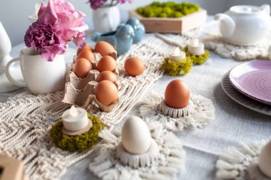 Paskalya için hoş, zarif bir sofra dekoru. El yapımı makrome ürünleri, yumurtalar.