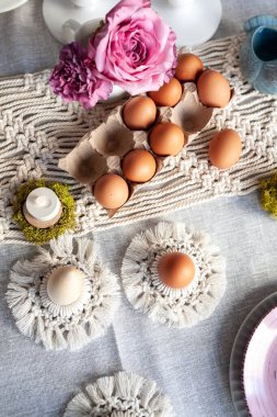 Paskalya için hoş, zarif bir sofra dekoru. El yapımı makrome ürünleri, yumurtalar.