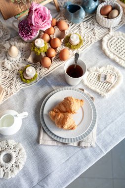 Paskalya için hoş, zarif bir sofra dekoru. El yapımı makrome ürünleri, yumurtalar.