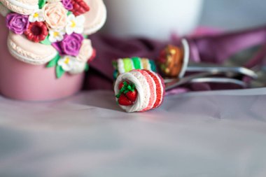 Polimer kil ile süslenmiş kupa ve kaşık bir buket gülün arka planında, el yapımı.