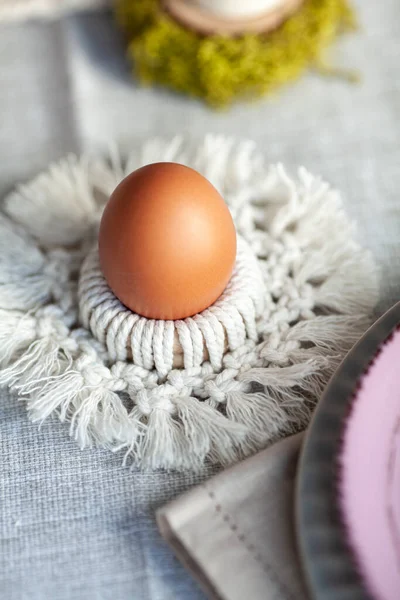 Cozy elegant festive table decor for Easter in a light tone. handmade macrame products, eggs.