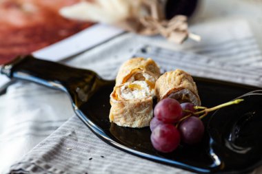 Tatlı suşi siyah bir tabakta eritilmiş bir şişeden yuvarlanıyor.