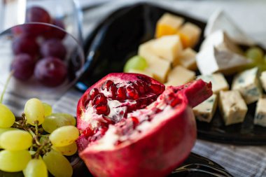 Farklı peynir ve üzümlü peynir tabağı eritilmiş bir şişeden şeffaf bir tabakta servis ediliyor.