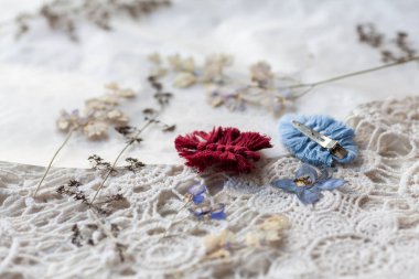 Kuru yapraklar ve dantellerin arka planına karşı makrome tekniğinde bir yaprak şeklinde saç tokası.