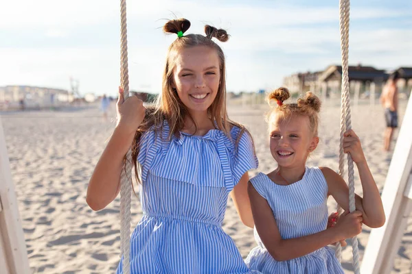 Duas Meninas Irmãs Felizes Bonitas Estão Balançando Balanço Pelo Mar — Fotografia de Stock