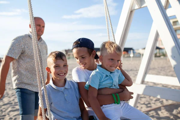 Pai Feliz Balança Seus Filhos Balanço Junto Mar Grande Família — Fotografia de Stock