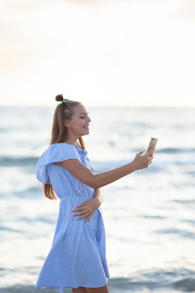 Schöne Glückliche Teenagerin Mit Smartphone Die Bei Sonnenuntergang Sandstrand Entlang — Stockfoto