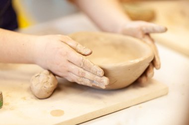 Çömlek atölyesinde, el sanatları ve kil sanatı, çocuk yaratıcı aktiviteler, sanat eğitimi gibi konularda modellik yapan sevimli bir çocuk.