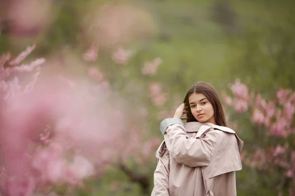 Vacker Flicka Vår Persika Trädgård Tonåring Klädd Regnrock Jeans — Stockfoto