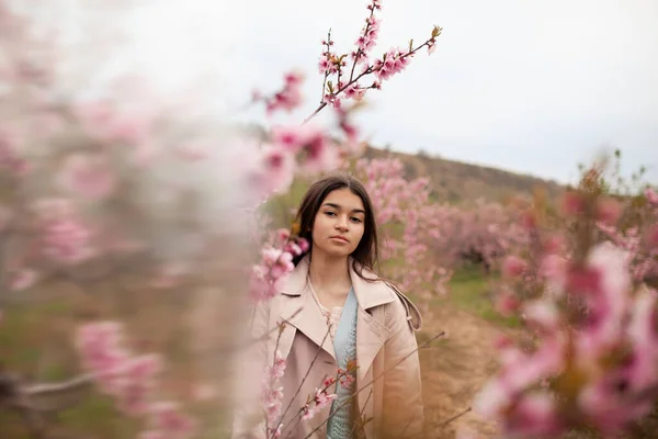 Krásná Dívka Jarní Broskvové Zahradě Teenager Oblečený Pláštěnce Džíny — Stock fotografie