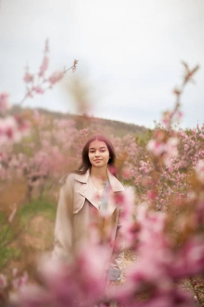 Krásná Dívka Jarní Broskvové Zahradě Teenager Oblečený Pláštěnce Džíny — Stock fotografie