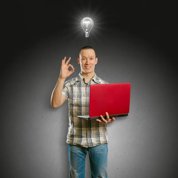 Ideia Conceito asiático macho com laptop em suas mãos mostra OK — Fotografia de Stock