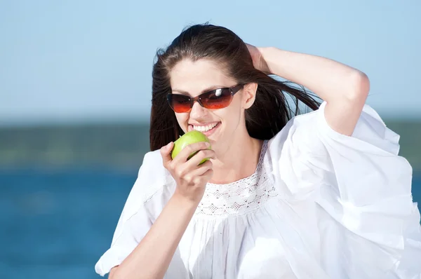 浜辺の果物を食べる女性 — ストック写真