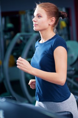 spor salonunda bir makinede çalışan genç bir kadın