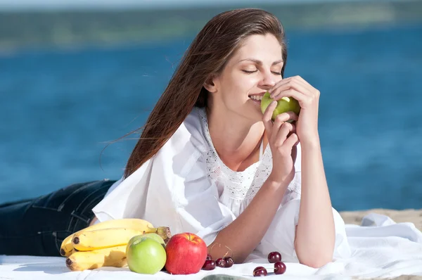 Kvinna på strand äta frukter — Stockfoto