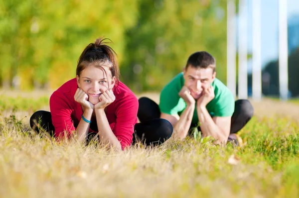 Man och kvinna kvinna gör yoga i park — Stockfoto