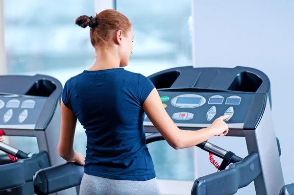 Jovem mulher no ginásio correr em uma máquina — Fotografia de Stock